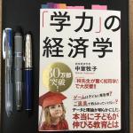 学力の経済学の本とノートとペン