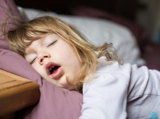 睡眠不足で口を開けて寝る少女
